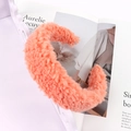Detailed texture of thick coral orange fuzzy lamb wool headband on decorative tray - Orange
