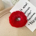Detailed view of fluffy red faux rabbit fur scrunchie on an elegant beige tray - Red