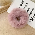 Detailed shot of soft pink faux rabbit fur scrunchie on a minimalist beige desktop - Lotus root pink