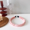 Detalle de diadema plisada rosa con textura satinada y terminaciones negras de tela - Rosa Carne