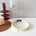 Detail of light yellow ruched headband with satin texture on a stylish white desk - Light Yellow