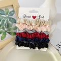 Detail of six colorful satin silk scrunchies set on a display card for elegant hairstyling - Bright Satin