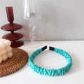 Close-up of light cyan ruched headband with soft black padded ends for comfort - Teal