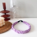 Vista detallada de la diadema de tela fruncida púrpura en un escritorio moderno - Morado