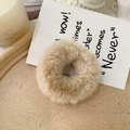 Close-up of soft apricot faux rabbit fur scrunchie on a tray with a warm aesthetic - Beige
