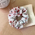 Détail d'un chouchou floral avec fleurs rouges sur livre vintage et table en bois - Style A Blanc Cassé