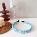 Detalle de la textura de tela de la diadema scrunchie azul claro con puntas protectoras - Azul claro