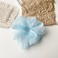 Detailed shot of a light blue organza scrunchie with soft ruffled texture on white fabric - Organza Sky Blue