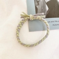 Detailed close-up of handmade braided elastic hair tie in purple and green woven textures - Grey Green