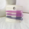 Gros plan de trois barrettes à cheveux dégradées violettes sur carte de produit - Série Violet Gris