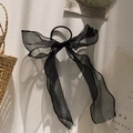 Detail eines glitzernden schwarzen Tüll-Haargummis mit langen Bändern und Gummiband - Schwarz