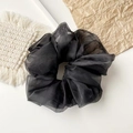 Detail eines schwarzen Oversize-Haargummis aus Organza mit plissierter Textur und Mesh-Stoff - Organza Schwarz