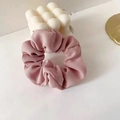 Detail eines rosa gerippten Scrunchies mit weicher Textur auf weißem Hintergrund - Rosa