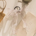 Detail of white semi-transparent chiffon bow hair tie with long ribbons on straw bag - Grey-Beige