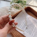 Detail shot of elegant large gradient pearls on a slim headband held in hand - 3# Gradient Beads White