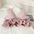 Close-up of pink flannel bow headband with ruffle trim for facial cleansing and skincare - Pink