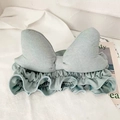 Detail of mint green fabric headband featuring a large bow on white fabric background - Light Blue