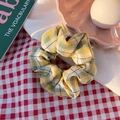 Detail eines gelb-grün karierten Scrunchies mit weicher Stoffstruktur und Gummiband - Mangopudding Gelb Grünes Gitter