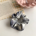 Close-up of blue and white plaid scrunchie with soft fabric texture on a desk - Blue White Plaid