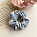 Detail of blue and apricot checkered hair scrunchie on a pink shell ceramic plate - Blue Apricot Plaid