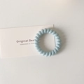 Macro detail of elastic light blue spiral telephone wire hair tie on a white card - Light Blue