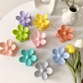 Matte Haarklammern in Blumenform in acht Pastellfarben auf einem weißen Schreibtisch - Gemischte Farben