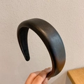 Primer plano de diadema negra de cuero PU grueso con acabado texturizado y acolchado suave - Negro