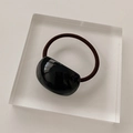 Détail d'un élastique à cheveux marron foncé avec un ornement en résine noire brillante - Corde à Cheveux Demi-Cercle Noir