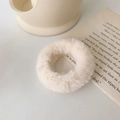 Détail d'un chouchou en fausse fourrure crème à texture douce sur un fond esthétique - Blanc Cassé