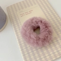 Close-up of a soft pink plush scrunchie showing faux fur texture on a grid notebook - Dusky Pink