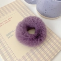 Close-up of soft purple faux fur scrunchie on a yellow checkered notebook background - Grape Purple