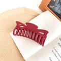 Deep red matte hair claw clip with elegant bow shape on vintage book background - Burgundy