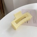 Detail view of large rectangular pale yellow matte hair claw clip with cutout design - Creamy White
