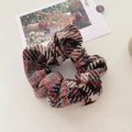 Detail of red and grey houndstooth plush scrunchie with soft knitted fabric texture - Orange Coffee Tones