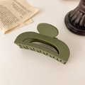 Detalle macro de la pinza para el pelo verde militar mate con acabado liso sobre crema - Verde Aguacate