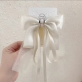Detail of cream oversized bow hair clip featuring satin layers and faux pearl beads - Beige Bow Streamer Duckbill Clip