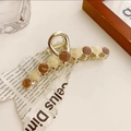 Dettaglio di un fermaglio per capelli dorato con inserti in resina sfumata - Arancio Crema-11cm