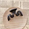 Pinza per capelli nera lucida a forma di onda con design a S su sfondo in legno - Nero