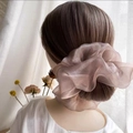 Detalle de un elegante coletero de organza rosa champán en cabello oscuro - Malva Nacarado Extra Grande