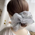 Primer plano de un elegante coletero de organza gris plata en una coleta de modelo - Gris Nacarado Extra Grande