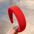 Detalle de una diadema acolchada roja brillante con etiqueta artesanal en el interior - Rojo