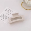 Detail view of large rectangular hollow hair claw clip in speckled beige matte finish - Speckled Beige