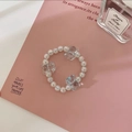Detail of beaded hair tie with cute bear charms and iridescent pearls on pink background - Mint Blue
