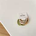 Detail van vier zeer elastische haarbanden in aardetinten met minimalistische verpakking - Lentekleuren Serie