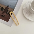 Primer plano de horquilla amarilla en forma de U para peinado minimalista en fondo creativo - Amarillo Leche