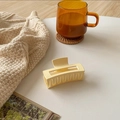 Close-up of a matte cream yellow rectangular hair claw clip on a cozy white desk - 8cm / Beige