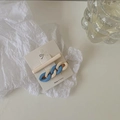 Detail view of interlocking chain hair clip and matte beige barrette on a display card - Blue & White