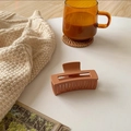 Macro detail of a rectangular matte hair claw clip in a warm vintage brick red color - 8cm / Orange