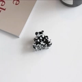 Close-up of a small bear-shaped acetate hair claw clip with black marble pattern - Bear Shape (Cow Print)