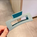 Vista detallada de una pinza para el pelo rectangular grande azul mate en la mano - Estilo Mate Grande / Azul